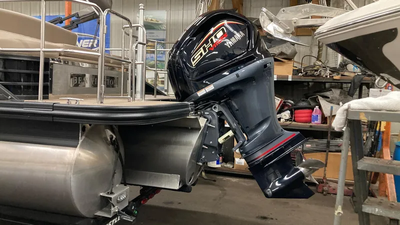 Slide: The Image of 2022 Bennington 25 LSB pontoon boat with powerful outboard motor in a workshop setting. - 7