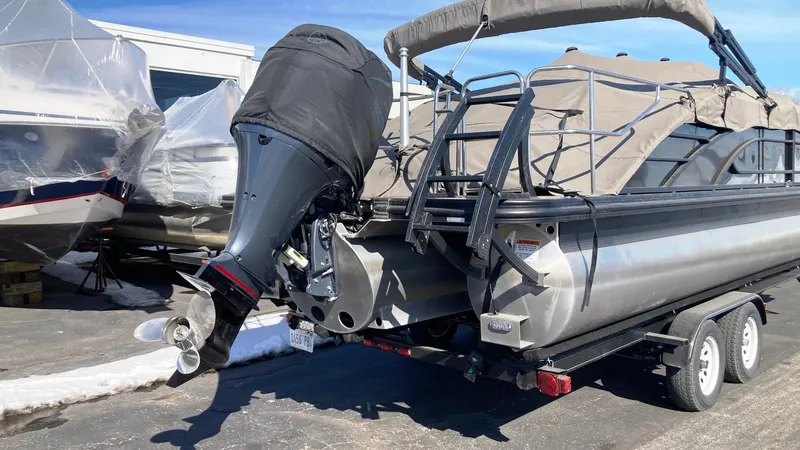 Slide: The Image of 2022 Bennington 25 LSB pontoon boat on trailer, covered and parked outdoors. - 8