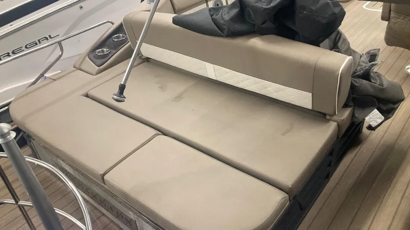 Slide: The Image of 2022 Bennington 25 LSB boat interior with beige seating and cup holders. - 9