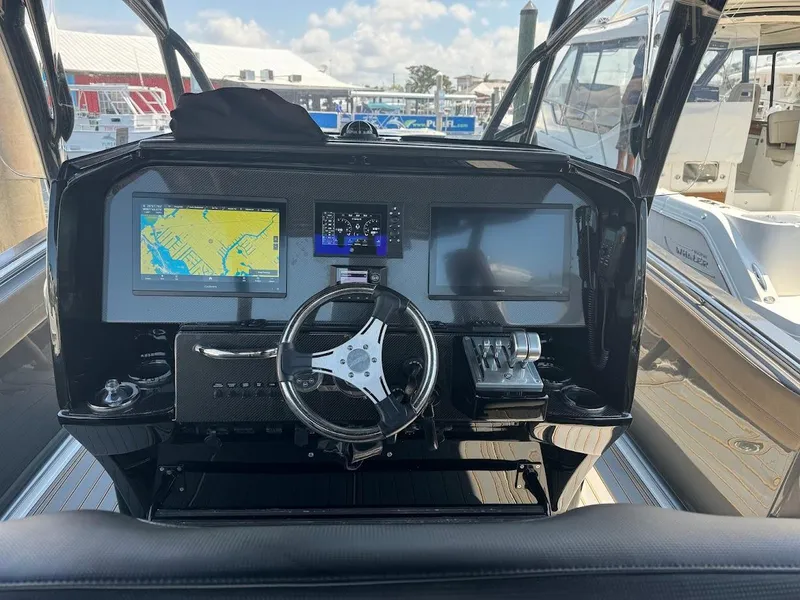 Slide: The Image of 2021 Nor-Tech 390 Sport Center Console dashboard with navigation screens and steering wheel. - 8