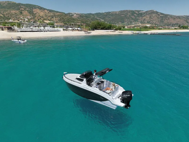 Slide: The Image of 2025 Ranieri NEXT 255 LX boat on clear turquoise water near a sandy beach. - 10