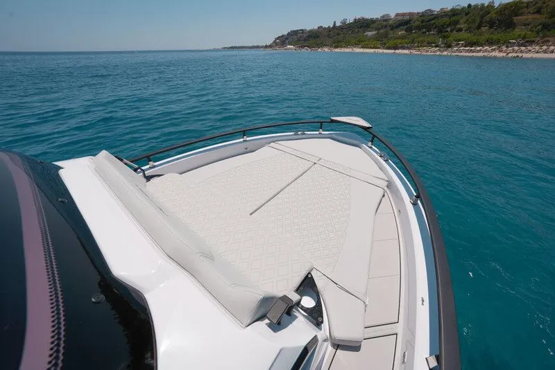 Slide: The Image of 2025 Ranieri NEXT 255 LX boat on clear blue water near a scenic coastline. - 29