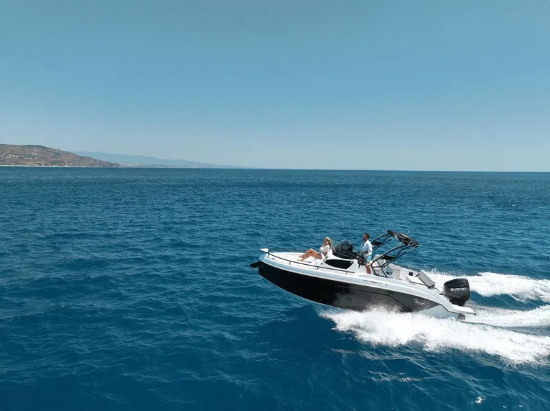 Slide: The Image of 2025 Ranieri NEXT 255 LX boat cruising on open sea under clear blue sky. - 6