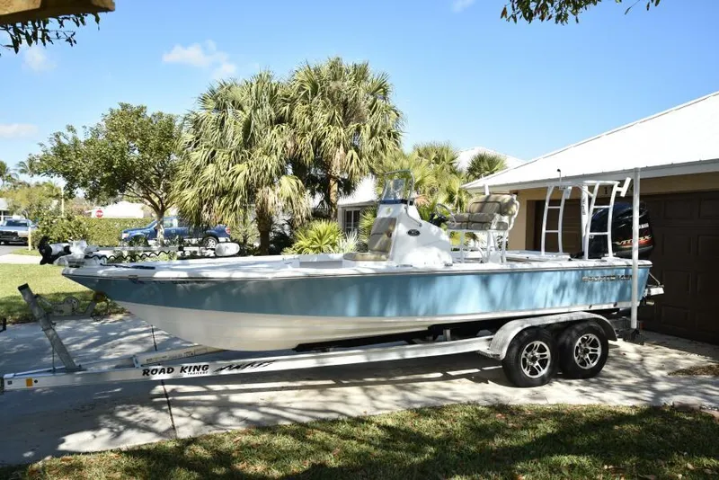 The Image of 2018 Sportsman Tournament 214 Bay Boat on trailer, parked in driveway, surrounded by palm trees. - 0