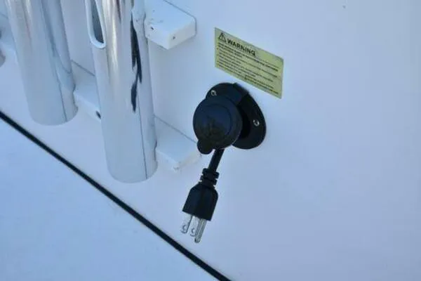 Slide: The Image of Power outlet on 2018 Sportsman Tournament 214 Bay Boat with plug connected. - 18