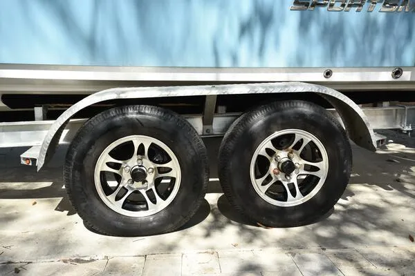 Slide: The Image of Trailer wheels of a 2018 Sportsman Tournament 214 Bay Boat in sunlight. - 34