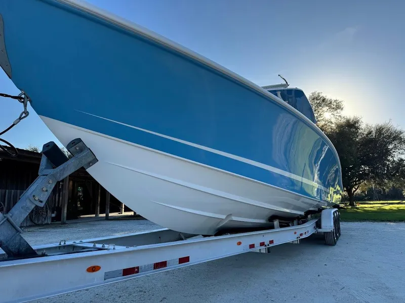 Slide: The Image of Blue Concept 392 Family Edition boat on trailer, 2018 model, parked outdoors. - 20
