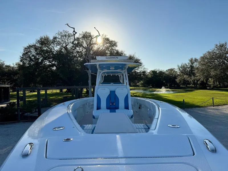 Slide: The Image of 2018 Concept 392 Family Edition boat with blue accents, parked outdoors under a clear sky. - 22