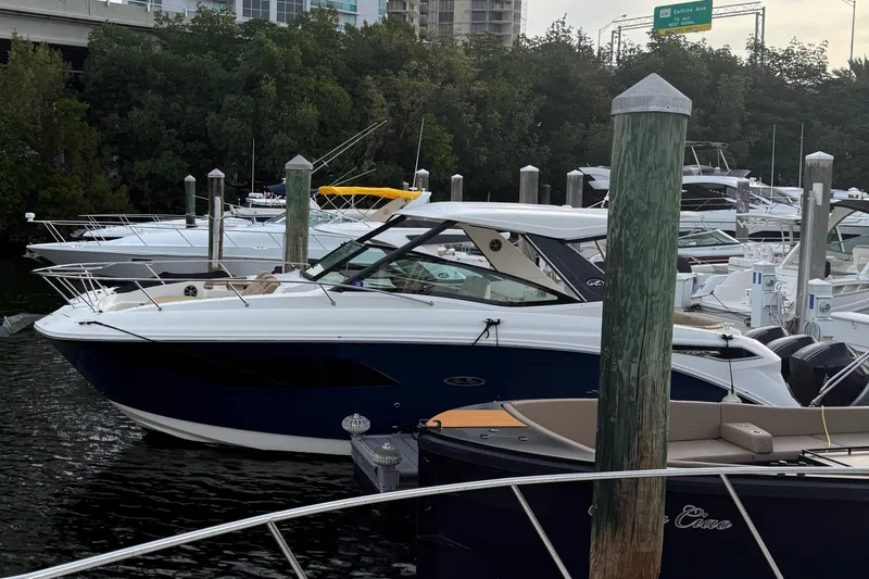 Slide: The Image of 2021 Sea Ray Sundancer 320 Coupe OB docked in a marina, surrounded by other boats. - 0