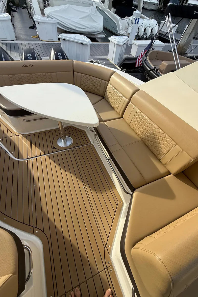 Slide: The Image of 2021 Sea Ray Sundancer 320 Coupe OB, luxurious tan seating with a sleek white table. - 10