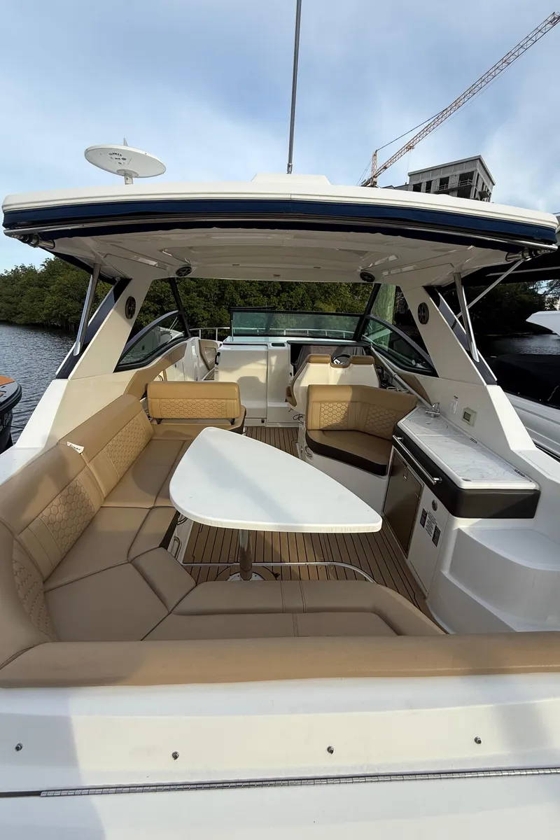 Slide: The Image of 2021 Sea Ray Sundancer 320 Coupe OB, spacious cockpit with seating and table, luxury design. - 11