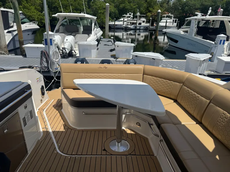 Slide: The Image of 2021 Sea Ray Sundancer 320 Coupe Outboard with elegant seating and table, docked at marina. - 12