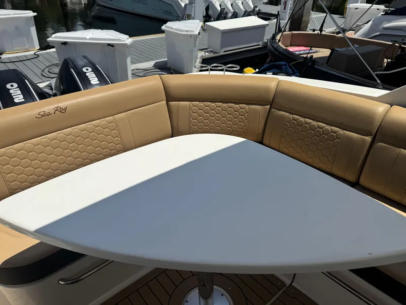 Slide: The Image of 2021 Sea Ray Sundancer 320 Coupe Outboard with tan seating and white table on deck. - 13