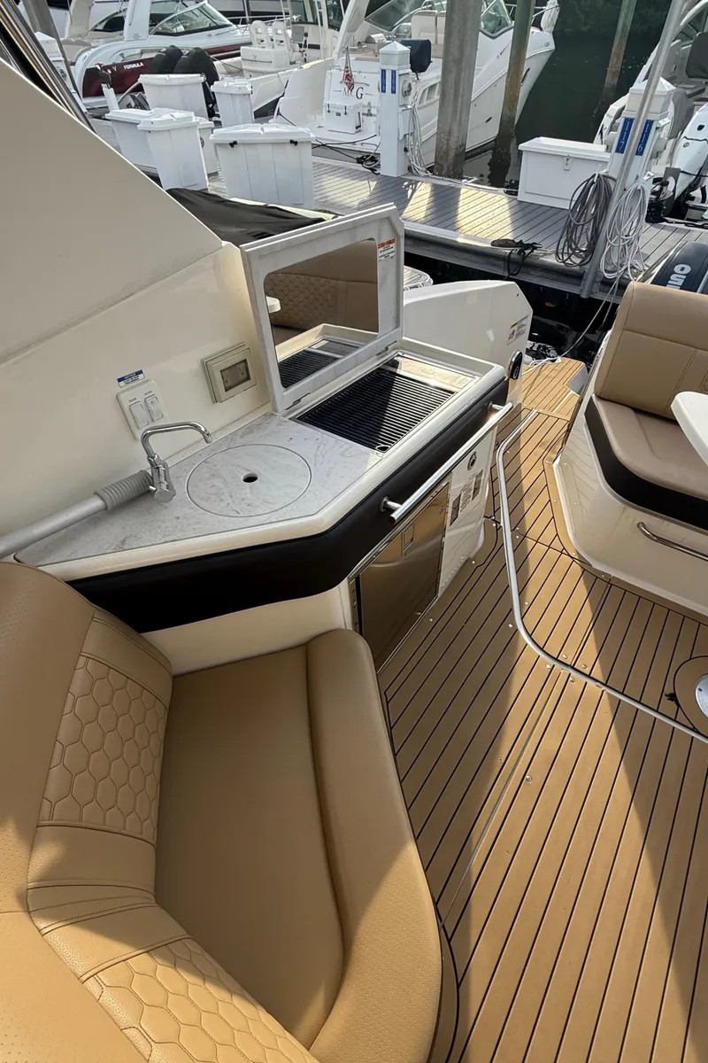 Slide: The Image of 2021 Sea Ray Sundancer 320 Coupe OB, luxurious deck with seating and kitchenette. - 14