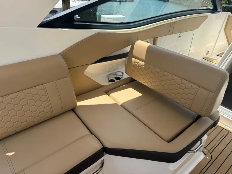 Slide: The Image of 2021 Sea Ray Sundancer 320 Coupe Outboard interior with tan leather seating and cup holders. - 20