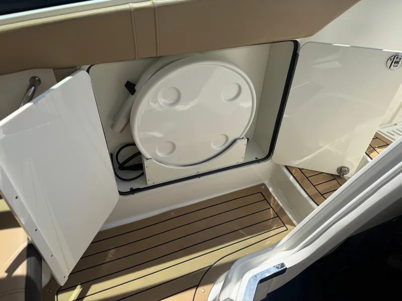Slide: The Image of 2021 Sea Ray Sundancer 320 Coupe Outboard storage compartment with open doors and wooden flooring. - 21