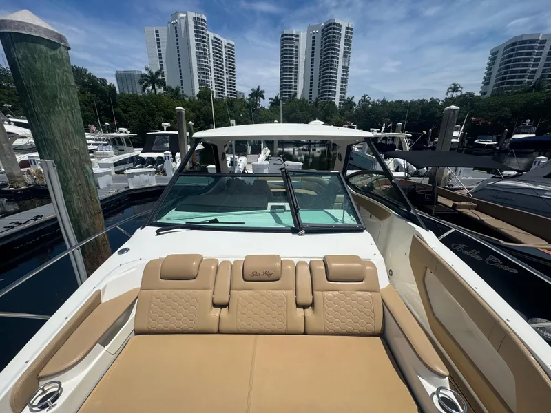Slide: The Image of 2021 Sea Ray Sundancer 320 Coupe Outboard docked, with city skyline in background. - 25