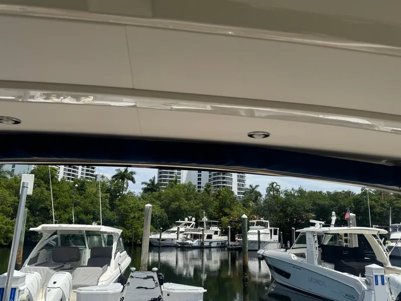 Slide: The Image of 2021 Sea Ray Sundancer 320 Coupe Outboard docked in a marina with other boats. - 27