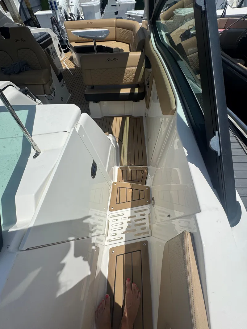 Slide: The Image of 2021 Sea Ray Sundancer 320 Coupe Outboard interior with tan seating and teak flooring. - 28