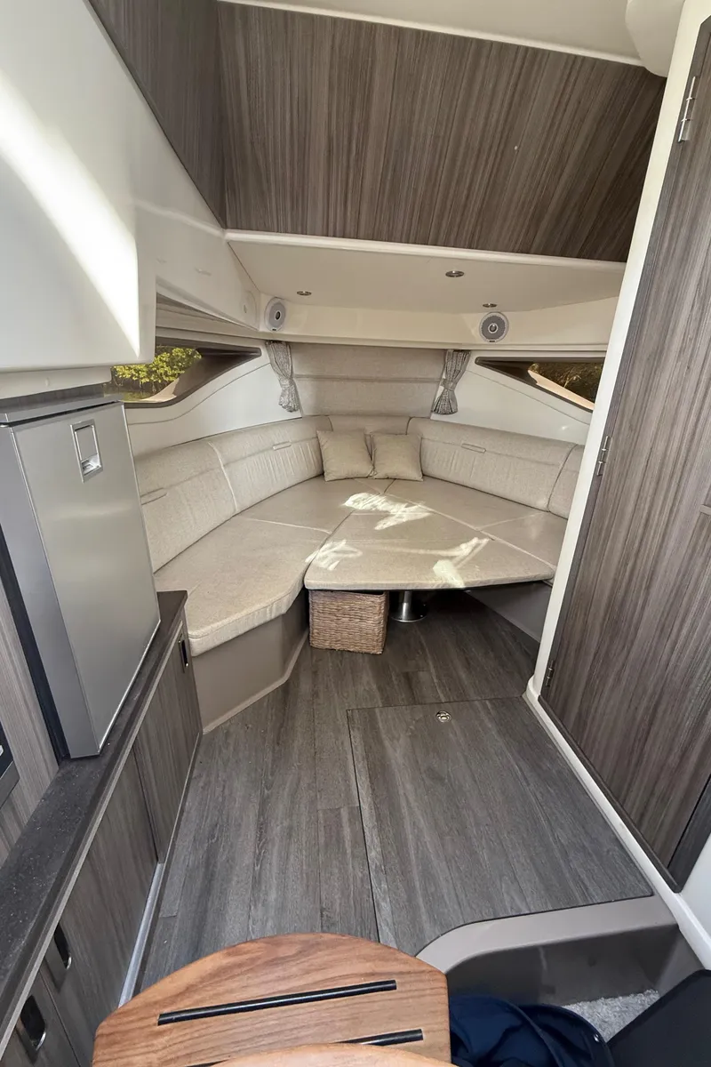 Slide: The Image of Interior of 2021 Sea Ray Sundancer 320 Coupe OB, featuring modern seating and wood accents. - 33