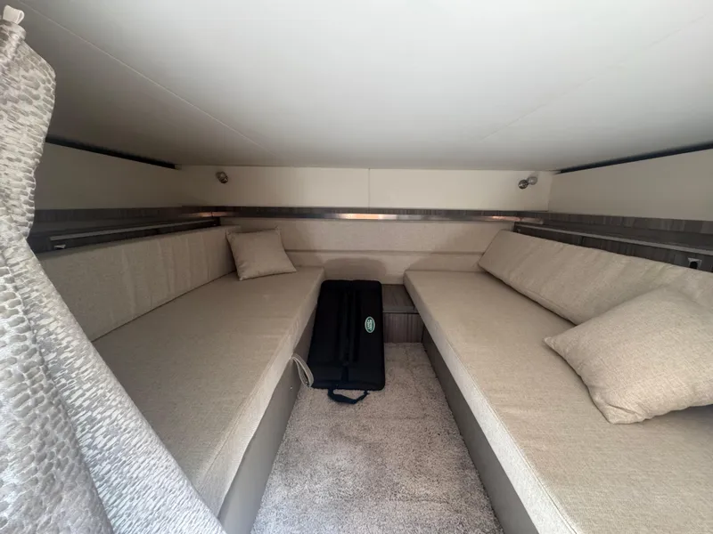 Slide: The Image of 2021 Sea Ray Sundancer 320 Coupe Outboard cabin interior with beige seating and cushions. - 37