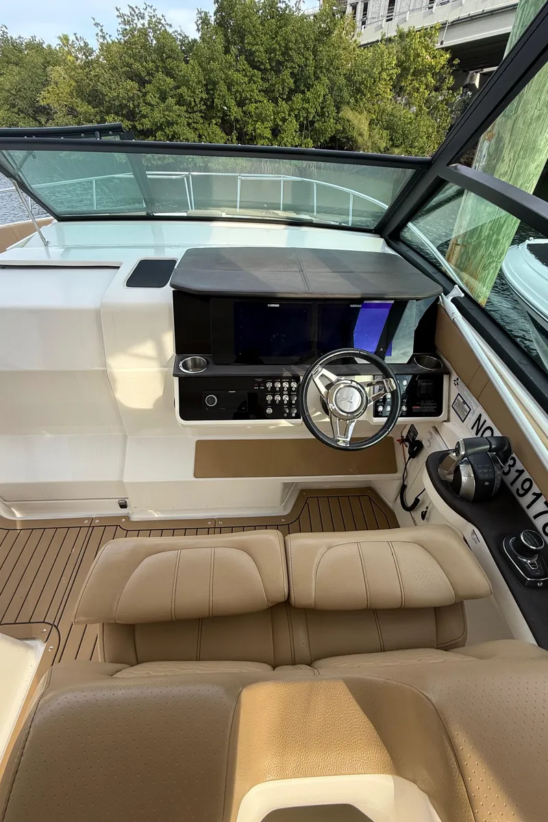 Slide: The Image of 2021 Sea Ray Sundancer 320 Coupe OB helm with modern controls and tan seating. - 4