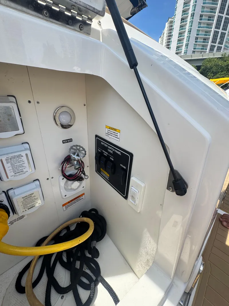 Slide: The Image of 2021 Sea Ray Sundancer 320 Coupe Outboard electrical panel with cables and switches. - 45