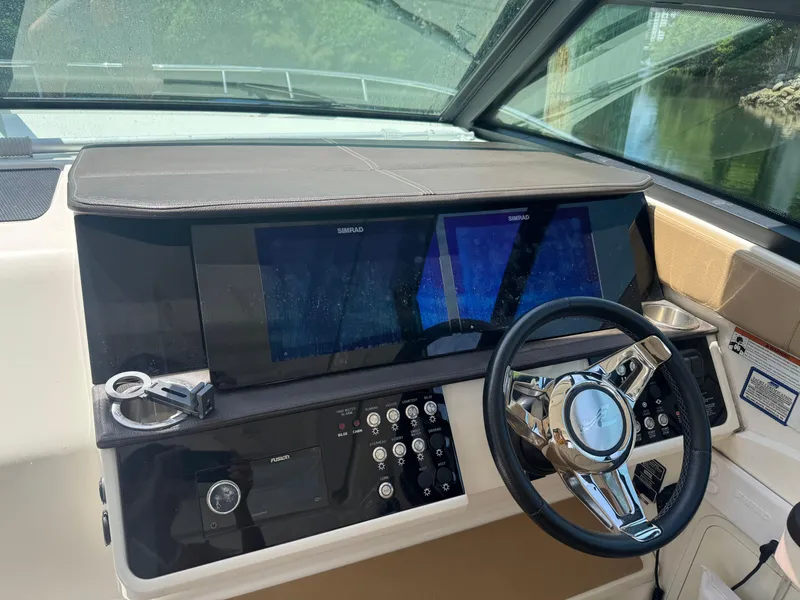 Slide: The Image of 2021 Sea Ray Sundancer 320 Coupe Outboard helm with Simrad displays and modern controls. - 5