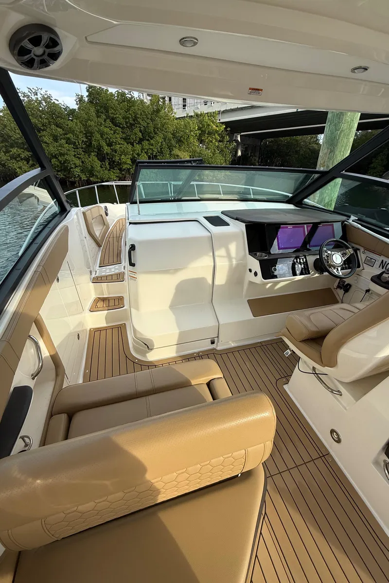 Slide: The Image of 2021 Sea Ray Sundancer 320 Coupe OB cockpit with tan seating and modern controls. - 8