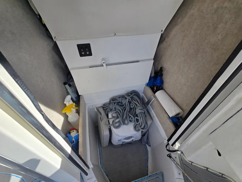 Slide: The Image of Storage compartment in a 2021 Ranger 2360 Bay boat with rope and cleaning supplies. - 12