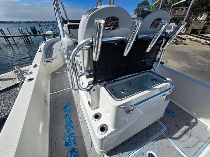 Slide: The Image of 2021 Ranger 2360 Bay boat interior with rod holders and livewell, docked by the water. - 20