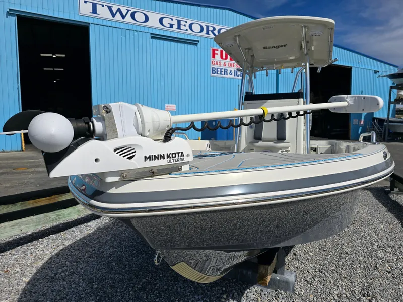 Slide: The Image of 2021 Ranger 2360 Bay boat with Minn Kota trolling motor, parked outside a blue building. - 3