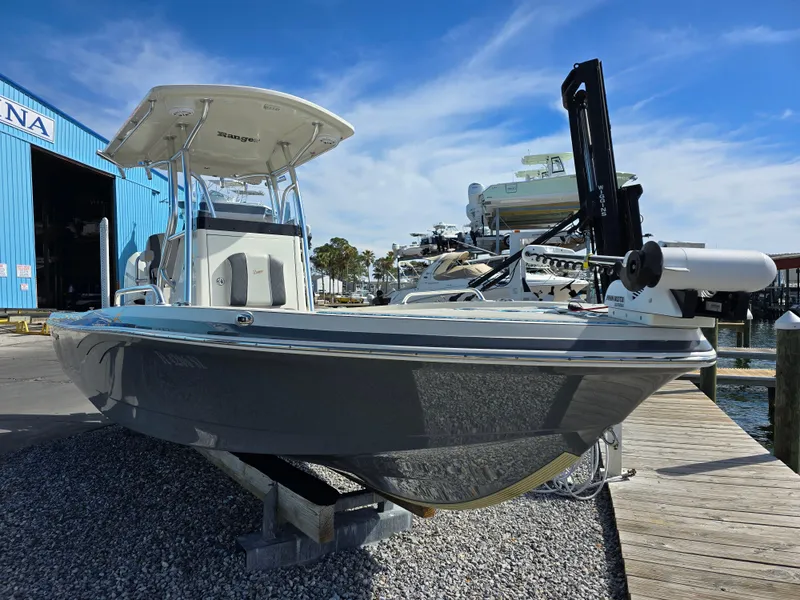 Slide: The Image of 2021 Ranger 2360 Bay boat docked near marina under clear blue sky. - 4