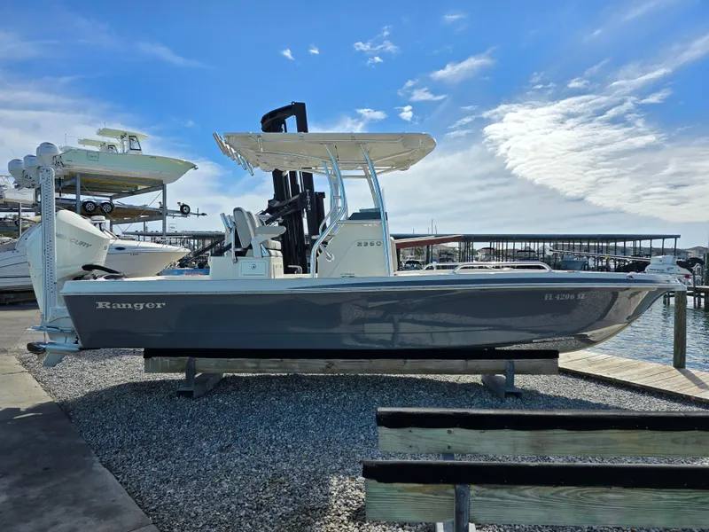 Slide: The Image of 2021 Ranger 2360 Bay boat docked under a clear blue sky. - 5