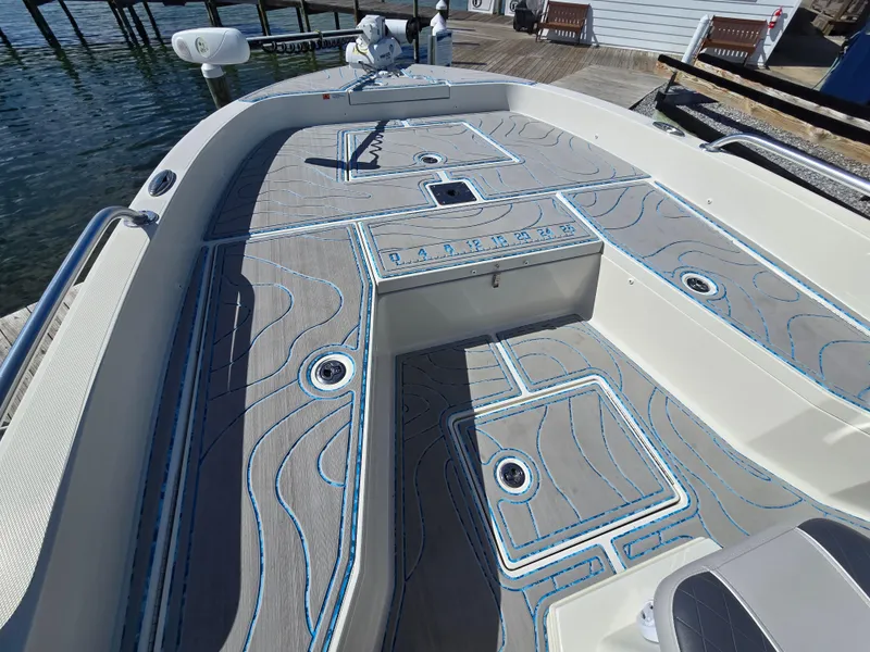 Slide: The Image of 2021 Ranger 2360 Bay boat with custom deck design, docked by the water. - 7