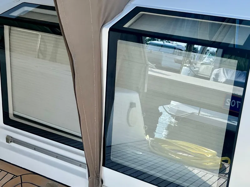 Slide: The Image of Lagoon 620 yacht window view, 2017 model, with dock reflection and coiled yellow hose. - 15