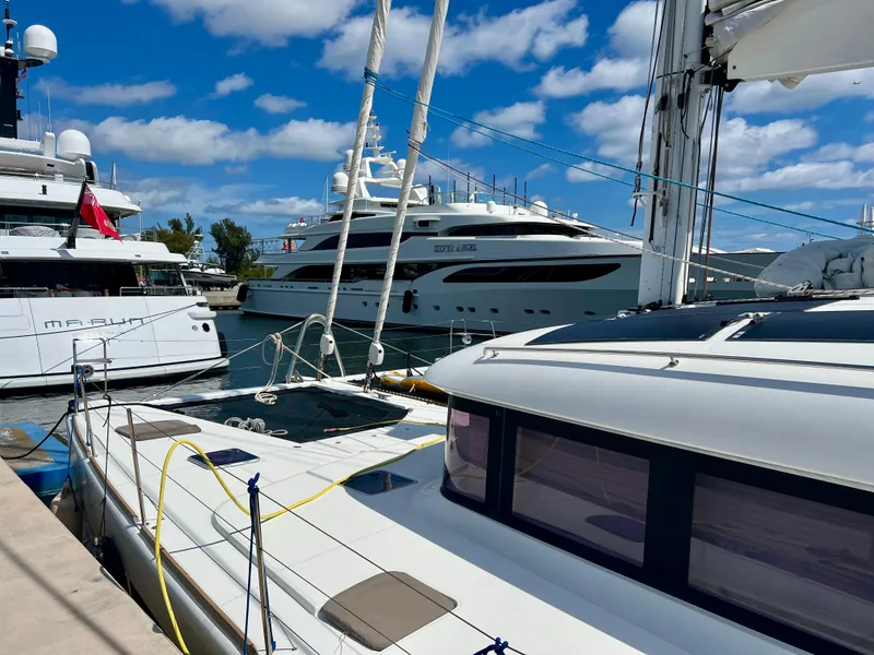 Slide: The Image of 2017 Lagoon 620 yacht docked with luxury boats under blue sky. - 3