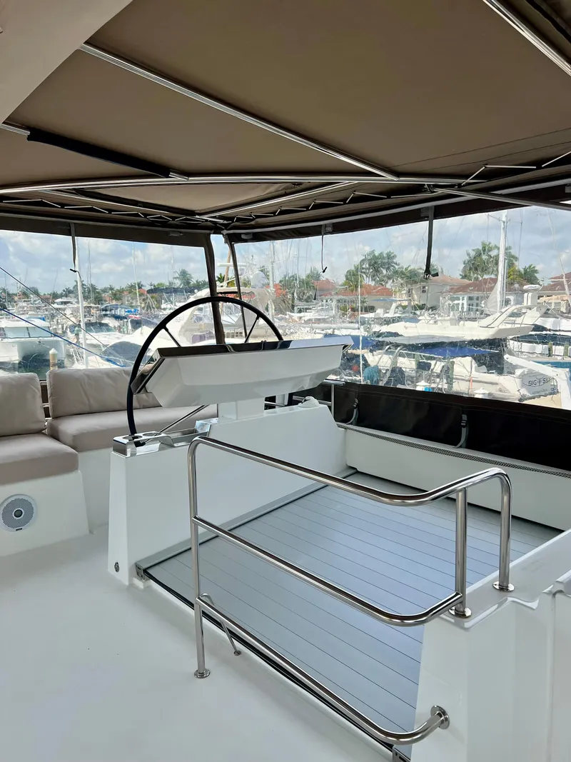 Slide: The Image of 2017 Lagoon 620 yacht helm station with seating, docked at marina. - 31