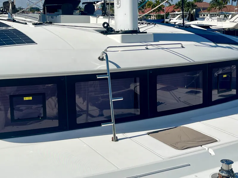 Slide: The Image of Lagoon 620 catamaran, 2017 model, featuring sleek windows and deck details in a marina setting. - 4