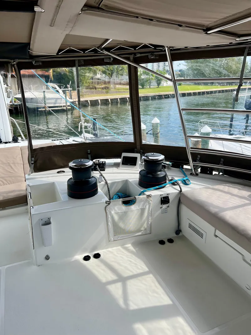 Slide: The Image of 2017 Lagoon 620 yacht cockpit with winches and seating, docked by the water. - 40