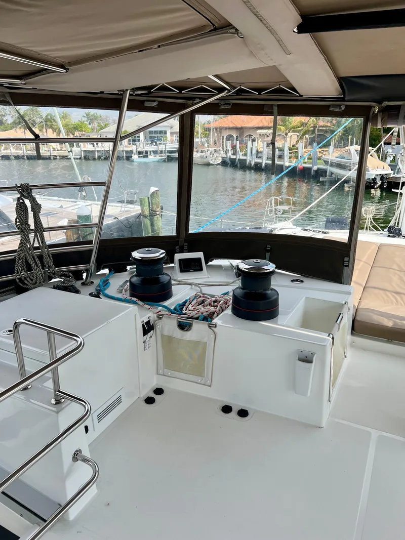 Slide: The Image of 2017 Lagoon 620 yacht cockpit with winches and navigation equipment, docked at a marina. - 45