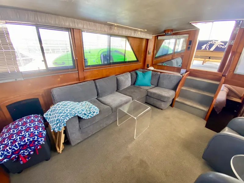Slide: The Image of 1988 Californian Sundeck Motoryacht interior with cozy seating, glass table, and nautical decor. - 17
