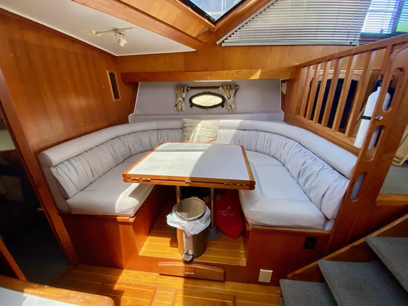Slide: The Image of 1988 Californian Sundeck Motoryacht interior with cozy dining area and wooden accents. - 21