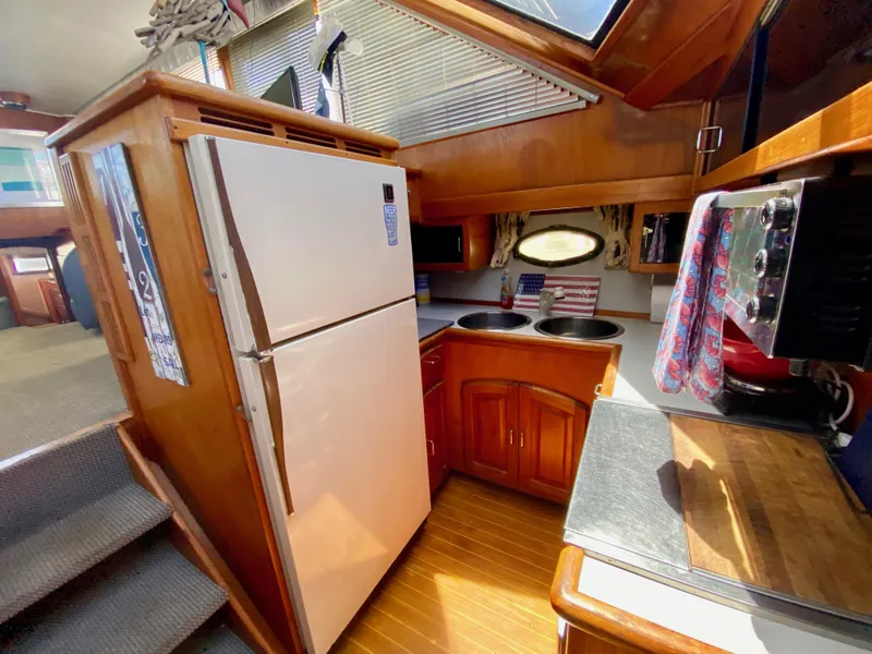 Slide: The Image of 1988 Californian Sundeck Motoryacht kitchen with wood cabinetry, refrigerator, and countertop appliances. - 23