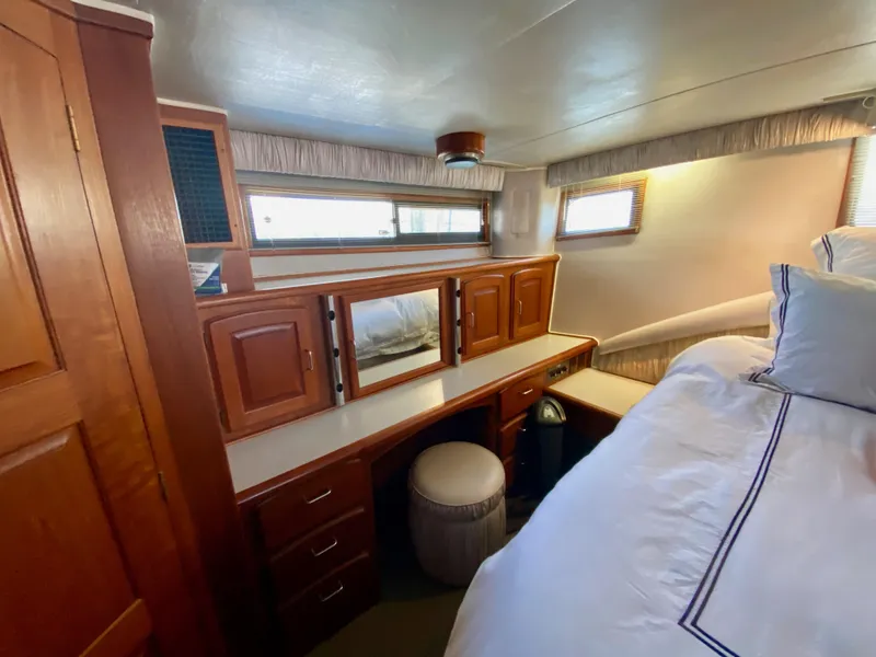 Slide: The Image of 1988 Californian Sundeck Motoryacht interior with wooden cabinetry and cozy bedding. - 27
