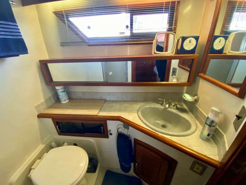 Slide: The Image of 1988 Californian Sundeck Motoryacht bathroom with sink, mirror, and toilet. - 29