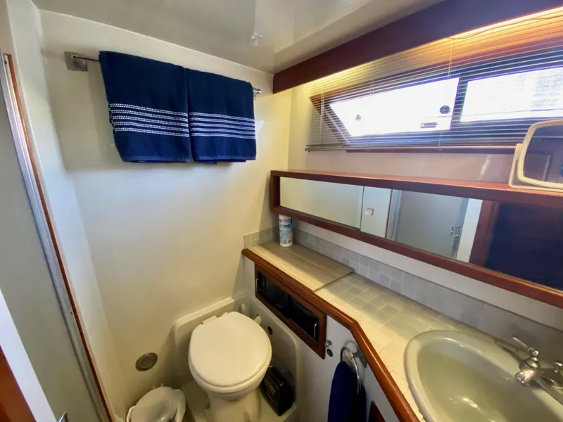 Slide: The Image of Bathroom interior of 1988 Californian Sundeck Motoryacht with sink, toilet, and window. - 30