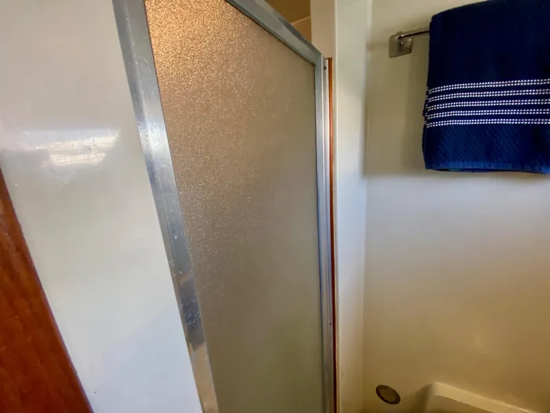 Slide: The Image of Shower area in 1988 Californian Sundeck Motoryacht with blue towel and frosted glass door. - 31