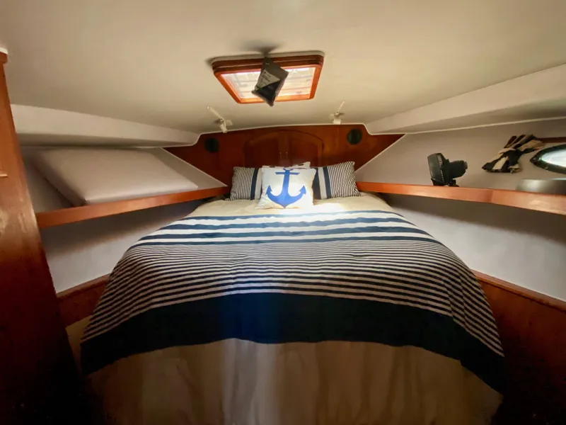 Slide: The Image of Cozy bedroom in 1988 Californian Sundeck Motoryacht with nautical-themed bedding. - 32
