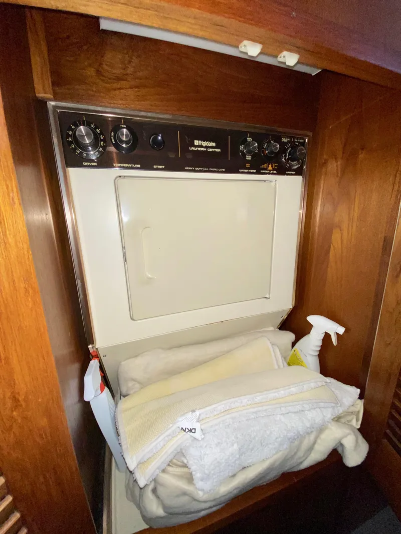 Slide: The Image of Laundry area with dryer in 1988 Californian Sundeck Motoryacht, featuring wooden cabinetry. - 34